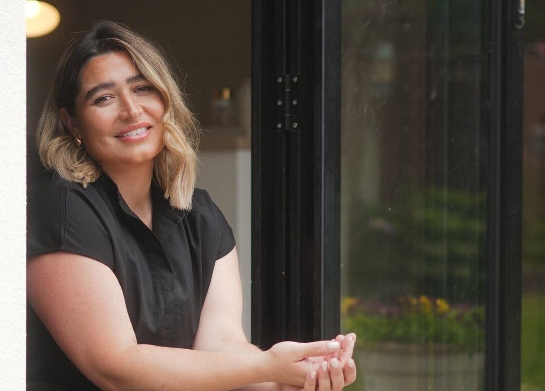 Smiling woman at Atelier Evie in Bawtry, England, enjoying a serene moment.