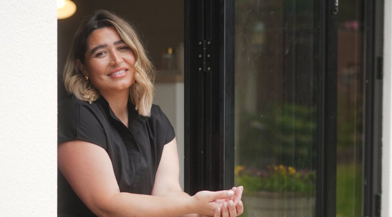 Smiling woman at Atelier Evie in Bawtry, England, enjoying a serene moment.