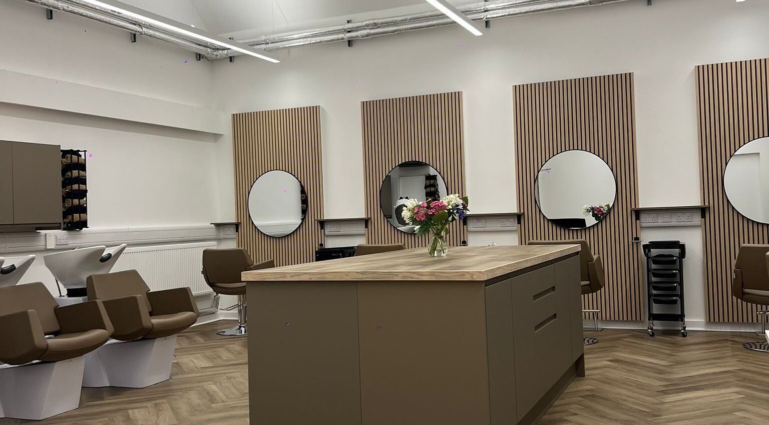 Modern salon interior at Envi Southwold in Southwold, England, GB with stylish chairs and mirrors.