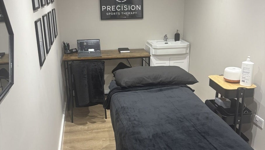 Modern therapy room at Precision Sports Therapy, Portsmouth, England, GB, featuring a treatment bed and sleek decor.