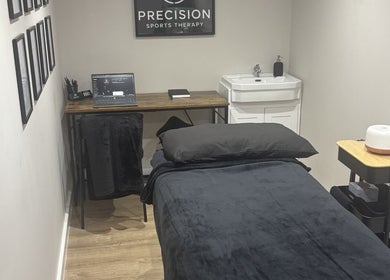 Modern therapy room at Precision Sports Therapy, Portsmouth, England, GB, featuring a treatment bed and sleek decor.