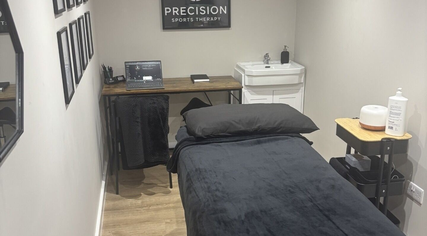 Modern therapy room at Precision Sports Therapy, Portsmouth, England, GB, featuring a treatment bed and sleek decor.
