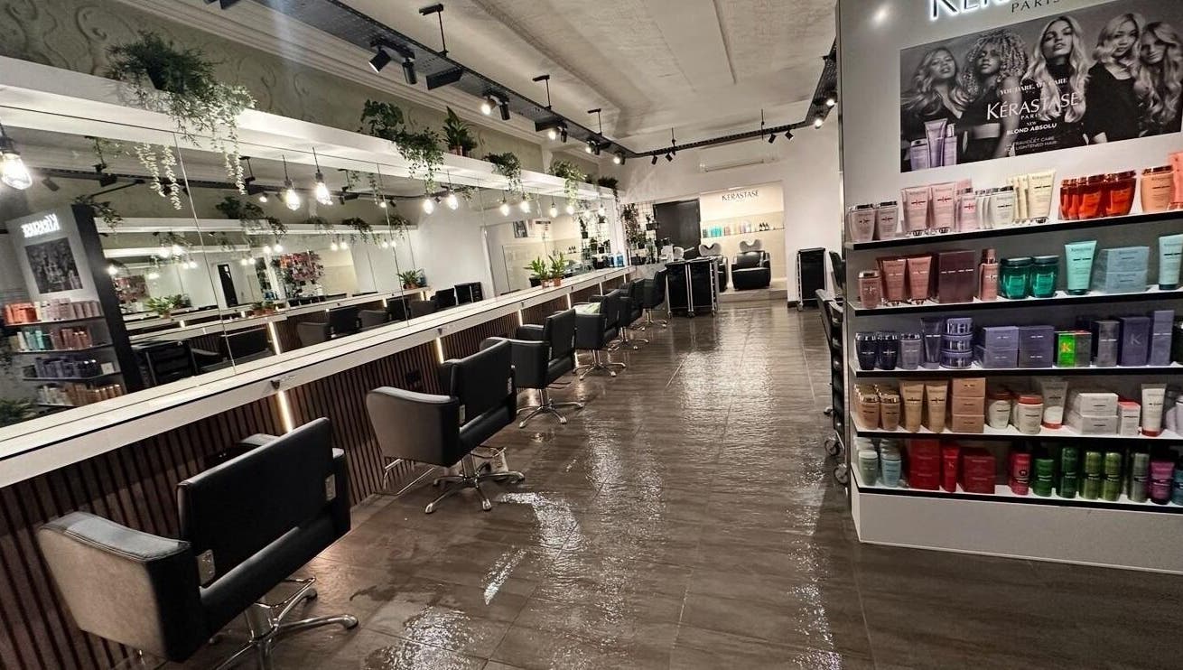 Modern salon interior at James Fulton Hair, Newcastle upon Tyne, England, GB, featuring styling chairs and product display.