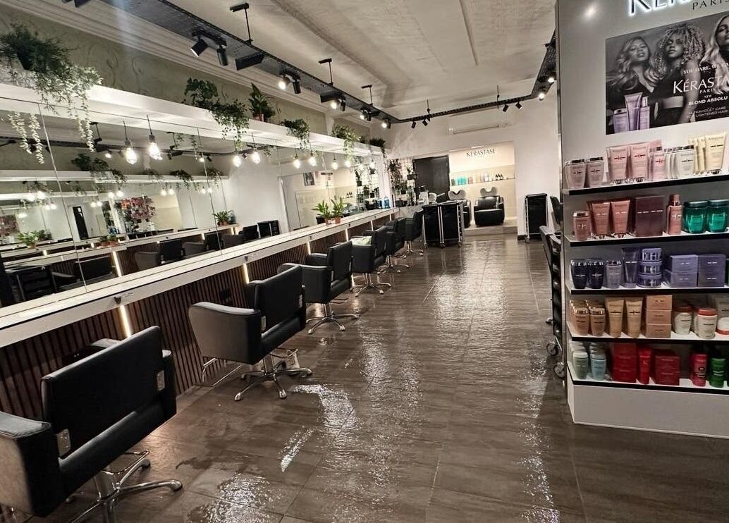 Modern salon interior at James Fulton Hair, Newcastle upon Tyne, England, GB, featuring styling chairs and product display.