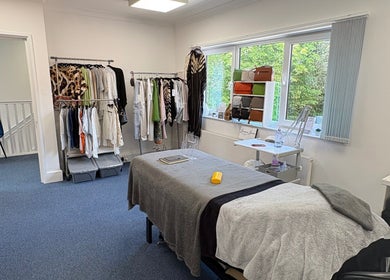 Relaxing treatment room at AmBhar Aesthetics, Hockley Heath, England, GB with massage bed and clothing rack.