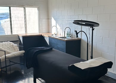Modern spa room at Morningside - Face Australia Co in Morningside, Queensland, AU with a massage table and cozy seating.