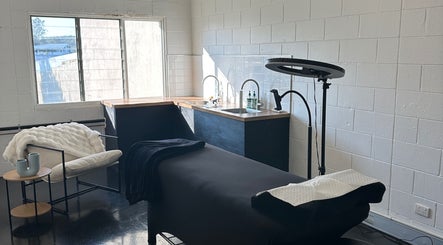Modern spa room at Morningside - Face Australia Co in Morningside, Queensland, AU with a massage table and cozy seating.