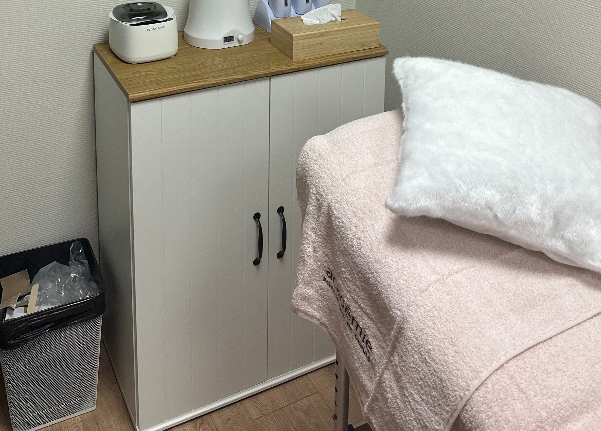 Cabine de soin élégante chez SKIN BY M à Nancy, Grand Est, FR. Mobilier moderne et table de massage.