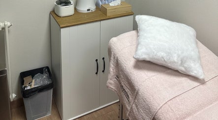 Cabine de soin élégante chez SKIN BY M à Nancy, Grand Est, FR. Mobilier moderne et table de massage.