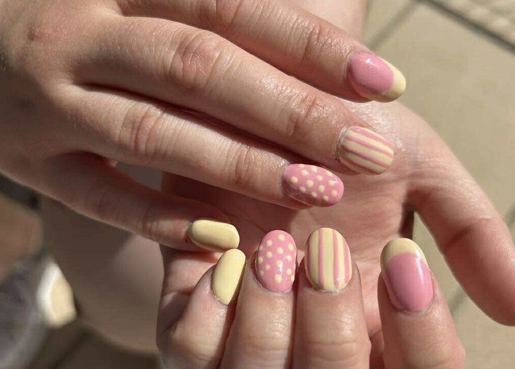 Pastelroze en gele nailart bij Nailtje Dijk in Westdorpe, Zeeland, NL. Unieke patronen en stijlvolle afwerking.