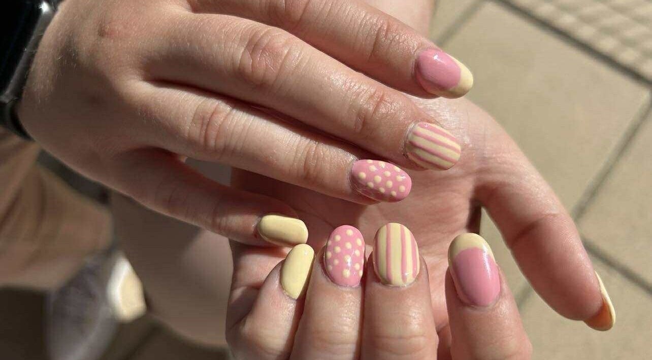 Pastelroze en gele nailart bij Nailtje Dijk in Westdorpe, Zeeland, NL. Unieke patronen en stijlvolle afwerking.