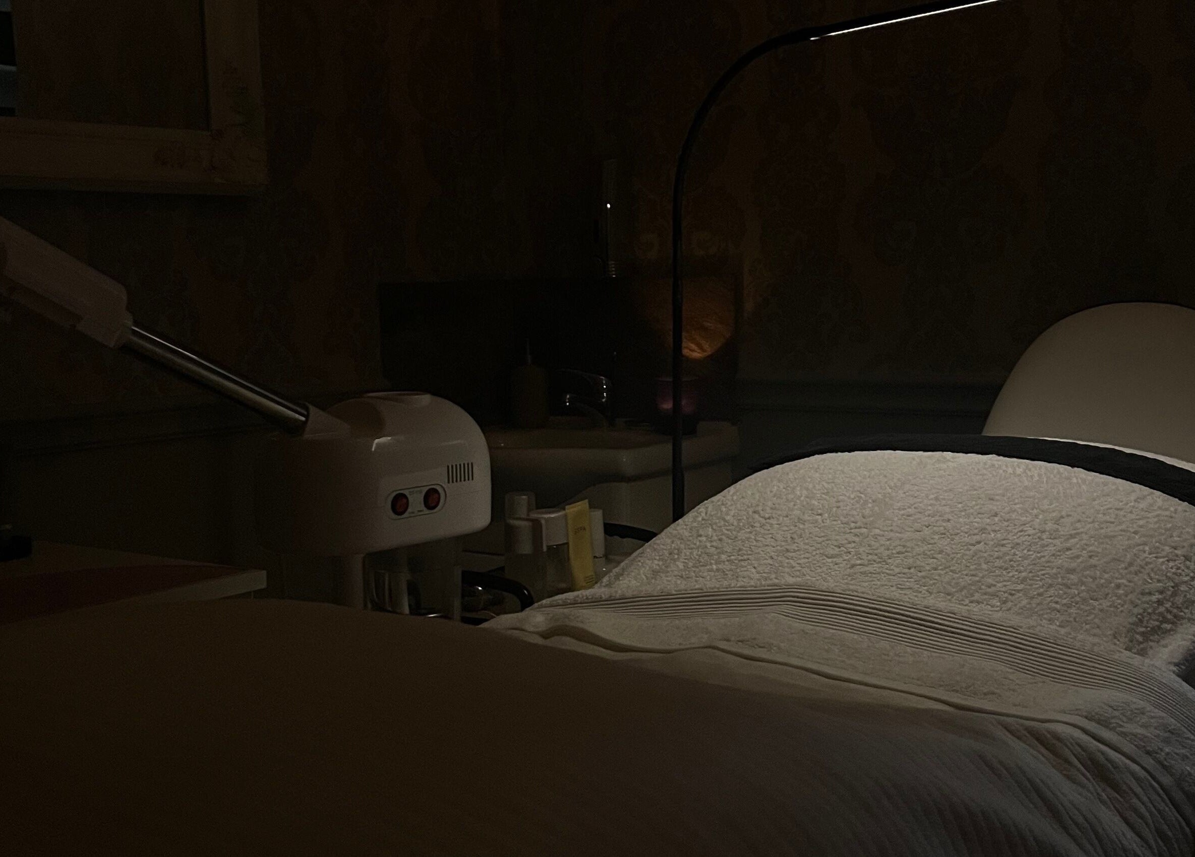 Relaxing treatment bed at The Essence Of Beauty, Chatburn, England, GB, in a warmly lit spa room.