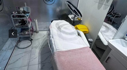 Cozy treatment room at Aura Beauty, London, England, GB, highlighting a serene spa bed and modern equipment.