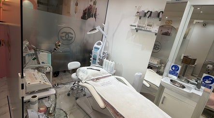 Aura Beauty's serene spa room in London, England, GB, featuring a modern treatment bed and skincare equipment.