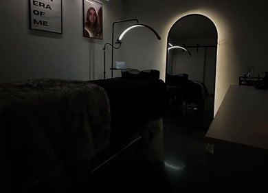 Интерьер салона красоты Natalia Maksymova в Калгари. Темное освещение, стильная мебель.