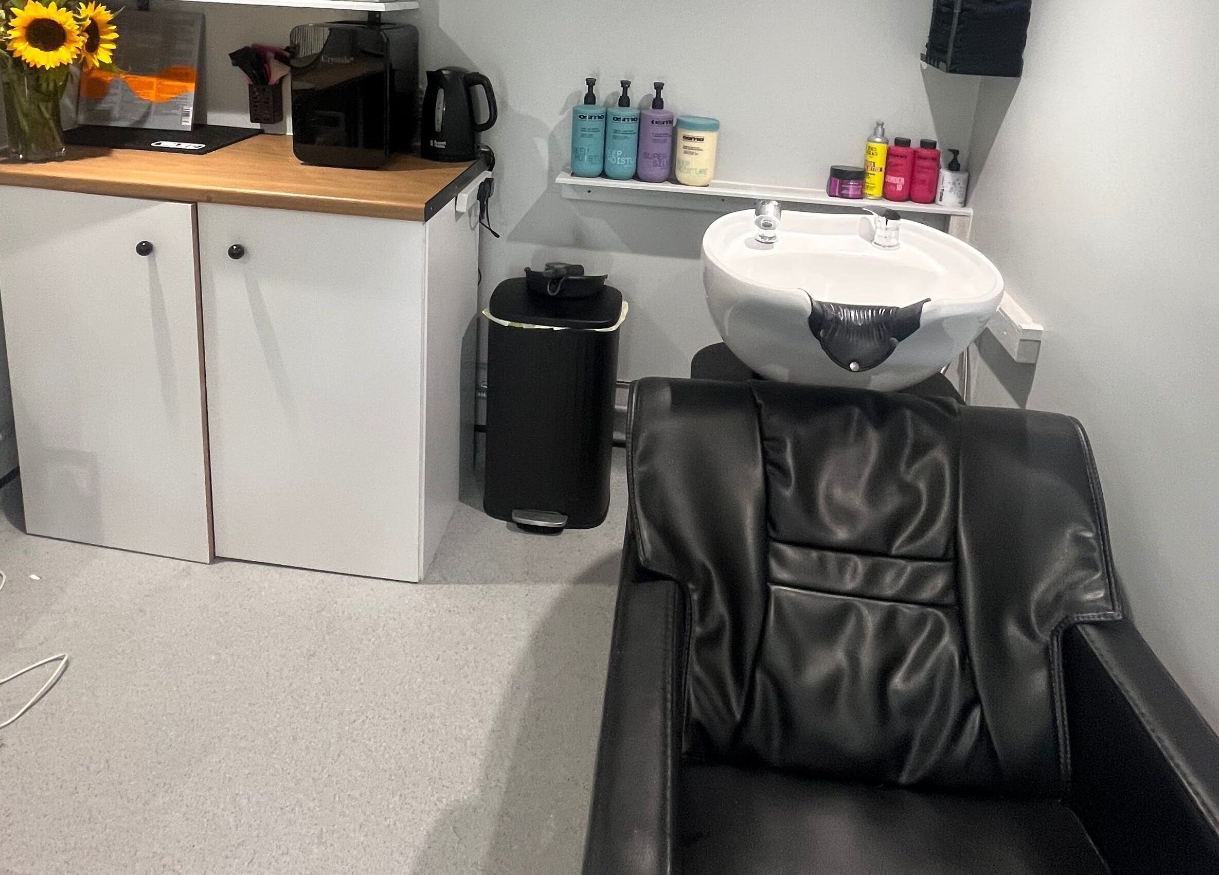Stylish wash station at Hair By Sophie Leah in Fifield, England, GB with sleek black chair and modern decor.