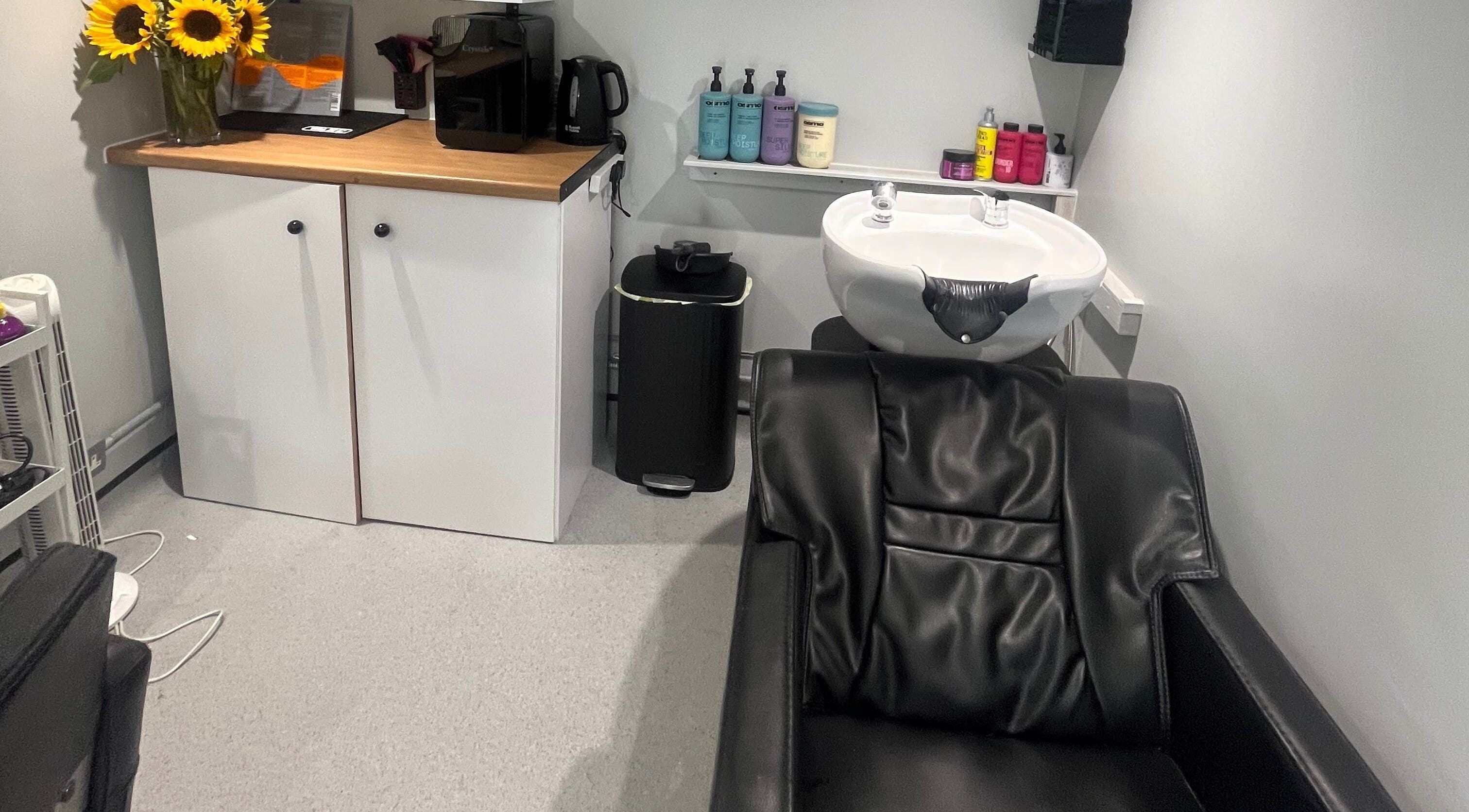 Stylish wash station at Hair By Sophie Leah in Fifield, England, GB with sleek black chair and modern decor.
