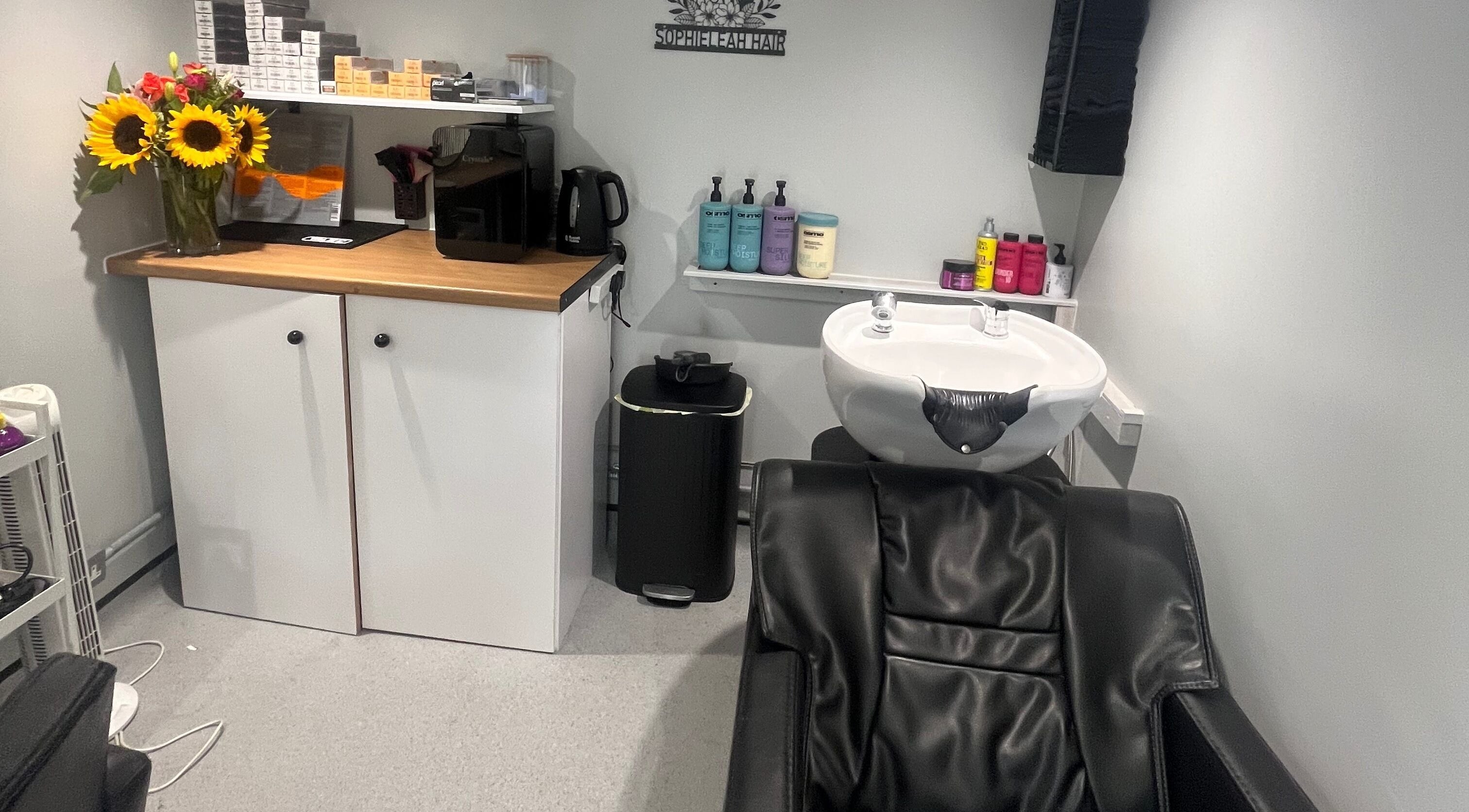 Chic salon interior at Hair By Sophie Leah, Fifield, England, GB showcasing wash station and vibrant decor.