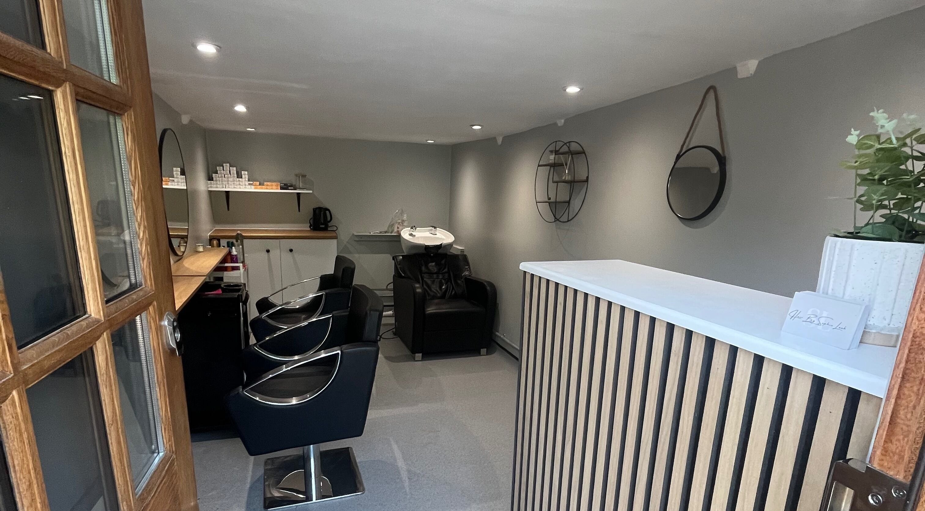Compact, stylish interior of Hair By Sophie Leah salon in Fifield, England, GB showcasing modern styling chairs.