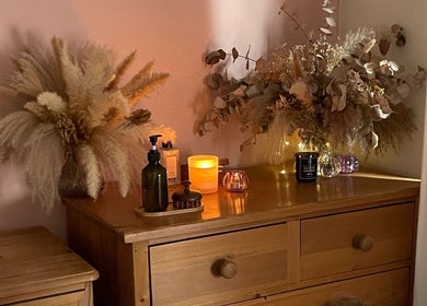 Elegant dresser with candles and foliage at Flow.S.Beauty Studio, Ash Vale, England, GB, creating a cozy atmosphere.