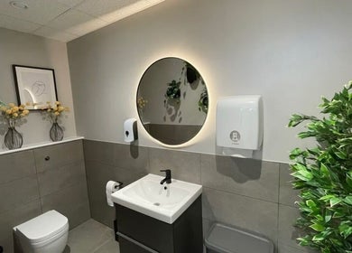 Chic restroom at Aesthetics by Katrina, London, England, GB featuring modern decor and vibrant green plants.