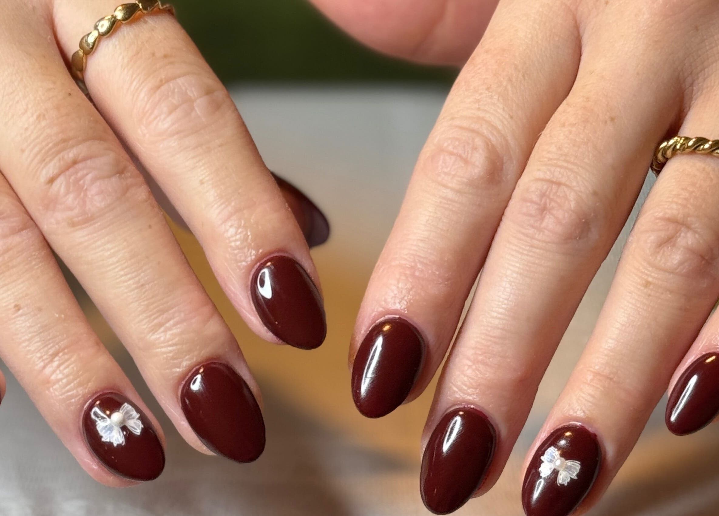 Elegant rood gelakte nagels met bloemdesign bij Pretty Nails in Zwolle, Overijssel, NL.