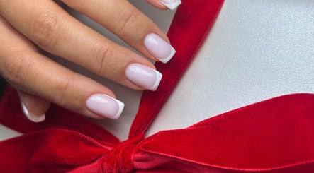 French manicure with red bow by Nails by Ilona in Chicago, United States, US.