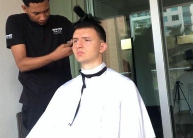 Barbero en Larioss Vip, Barranquilla, Atlántico, CO, realiza corte moderno al aire libre.