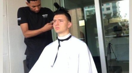 Barbero en Larioss Vip, Barranquilla, Atlántico, CO, realiza corte moderno al aire libre.