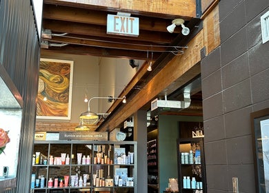 Interior of DZVINKA Beauty Studio with wooden beams and product shelves in Edmonton, Alberta, CA.