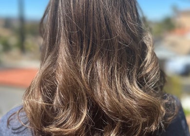 Brunette hair waves shine in sunlight at Hevani Touch, Riverside, California, US.
