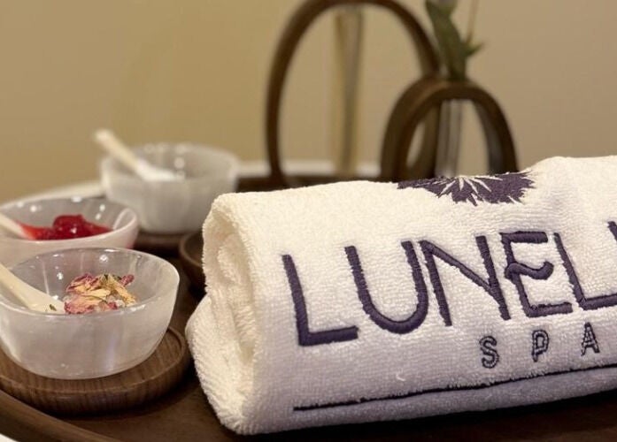 منشفة Lunelle Spa ومنتجات عناية على طبق خشبي في Lunelle Spa، الرياض، منطقة الرياض، السعودية.
