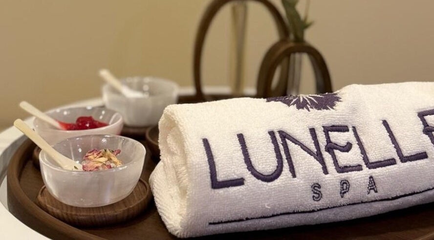 منشفة Lunelle Spa ومنتجات عناية على طبق خشبي في Lunelle Spa، الرياض، منطقة الرياض، السعودية.