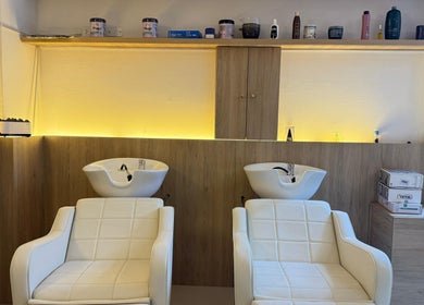 Zona de lavado en Seductiva Spa, Ayacucho, Ayacucho, PE con sillones blancos y muebles de madera.