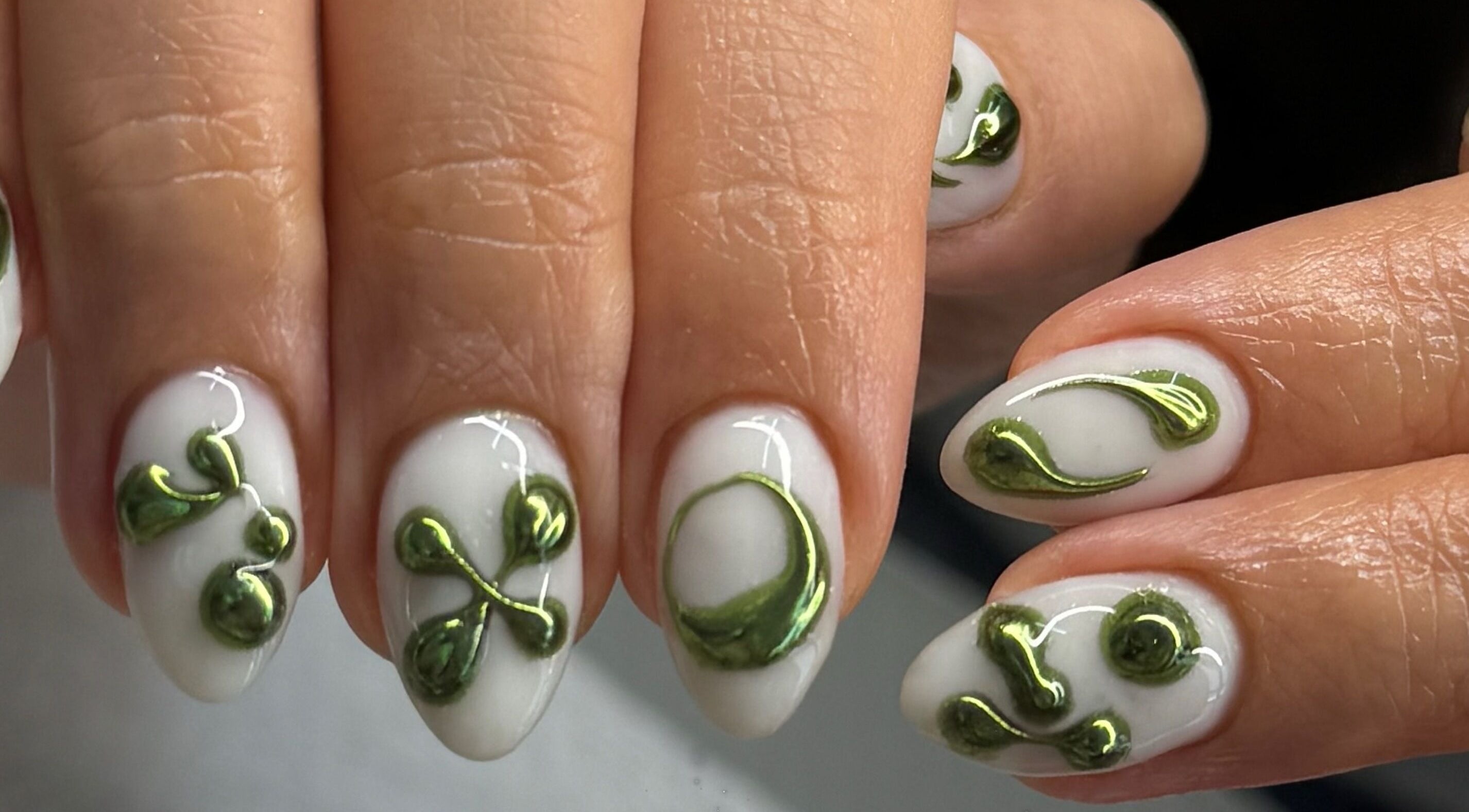 Intricate green nail art on white background at Nailspa, Singapore, SG offering eco-friendly beauty designs.