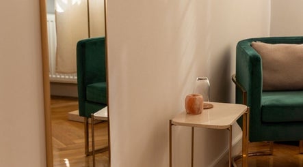 Elegancki kącik z zielonym fotelem w Irkha Massage, Warszawa, Województwo Mazowieckie, PL.