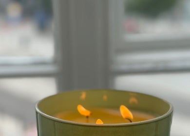 Płonąca żółta świeca w Irkha Massage, Warszawa, Województwo Mazowieckie, PL, tworzy relaksującą atmosferę.