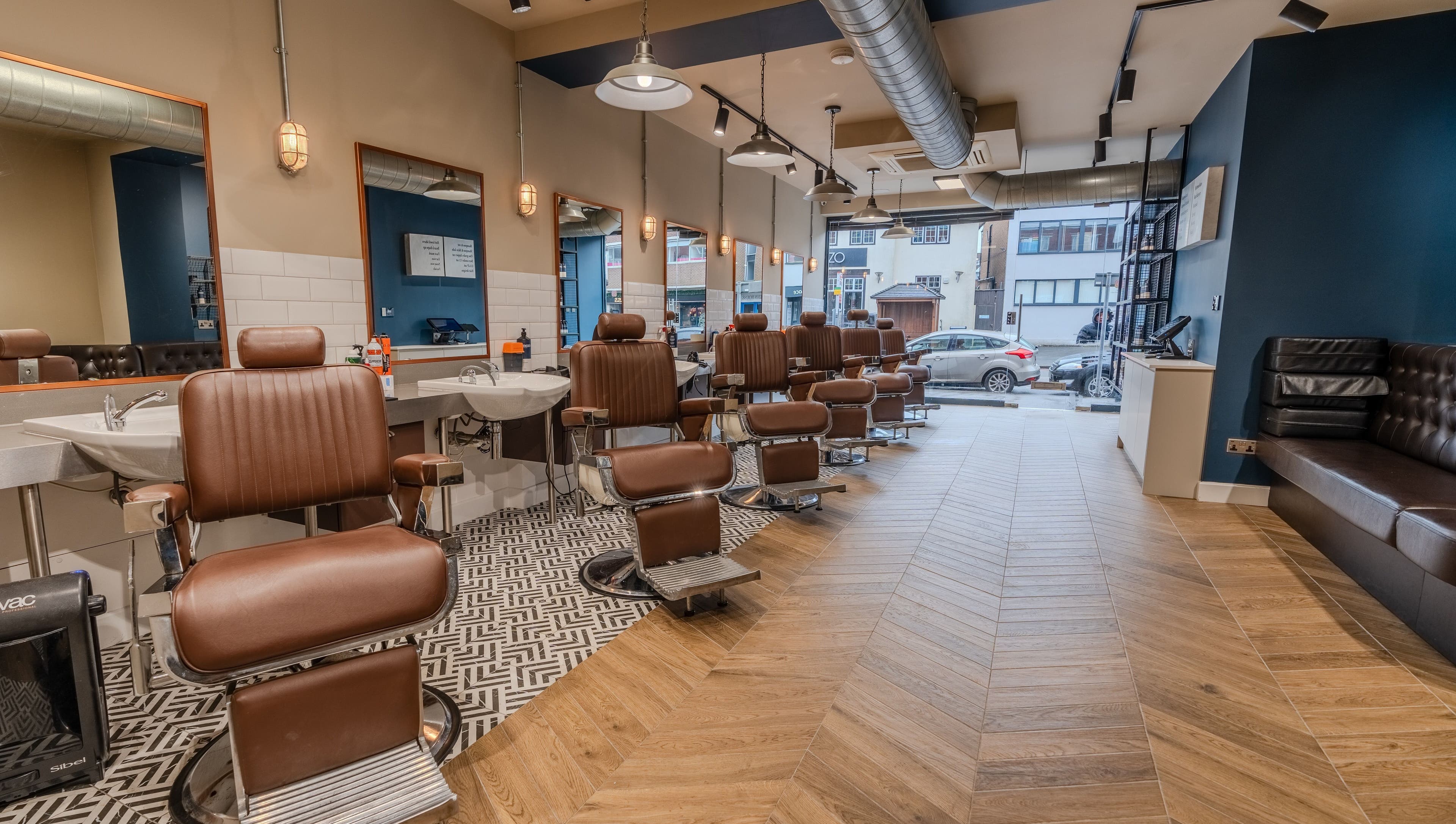 Vintage barber chairs at Sammies Studio - Banstead, England, GB, showcasing modern elegance and comfort.