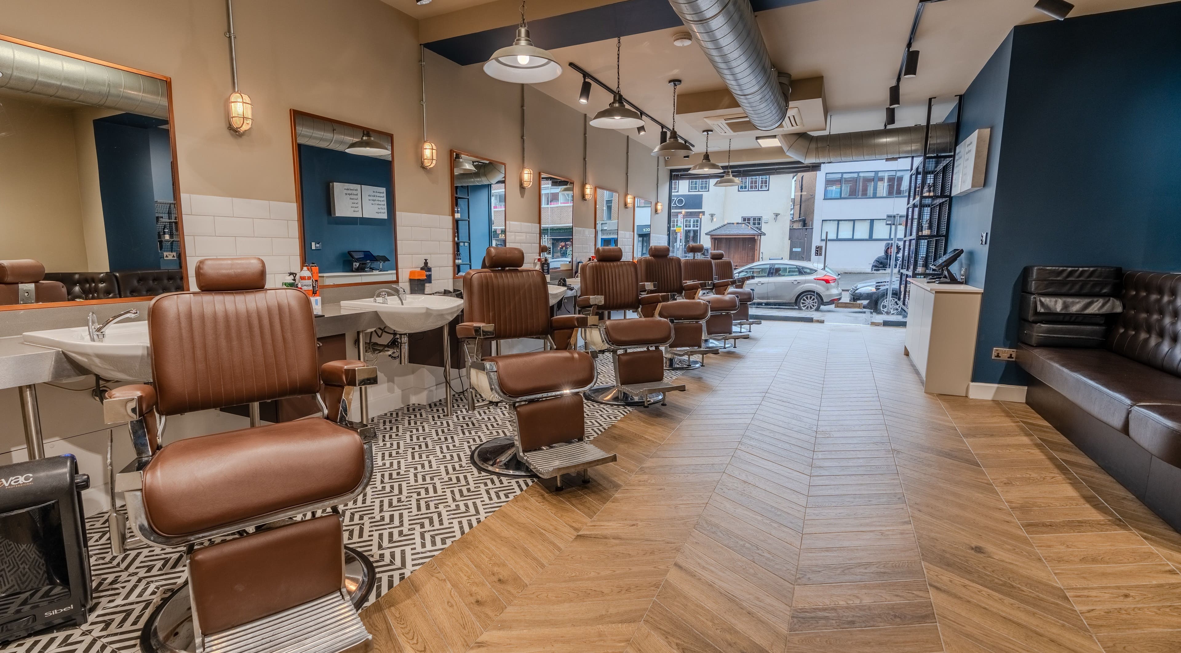 Vintage barber chairs at Sammies Studio - Banstead, England, GB, showcasing modern elegance and comfort.