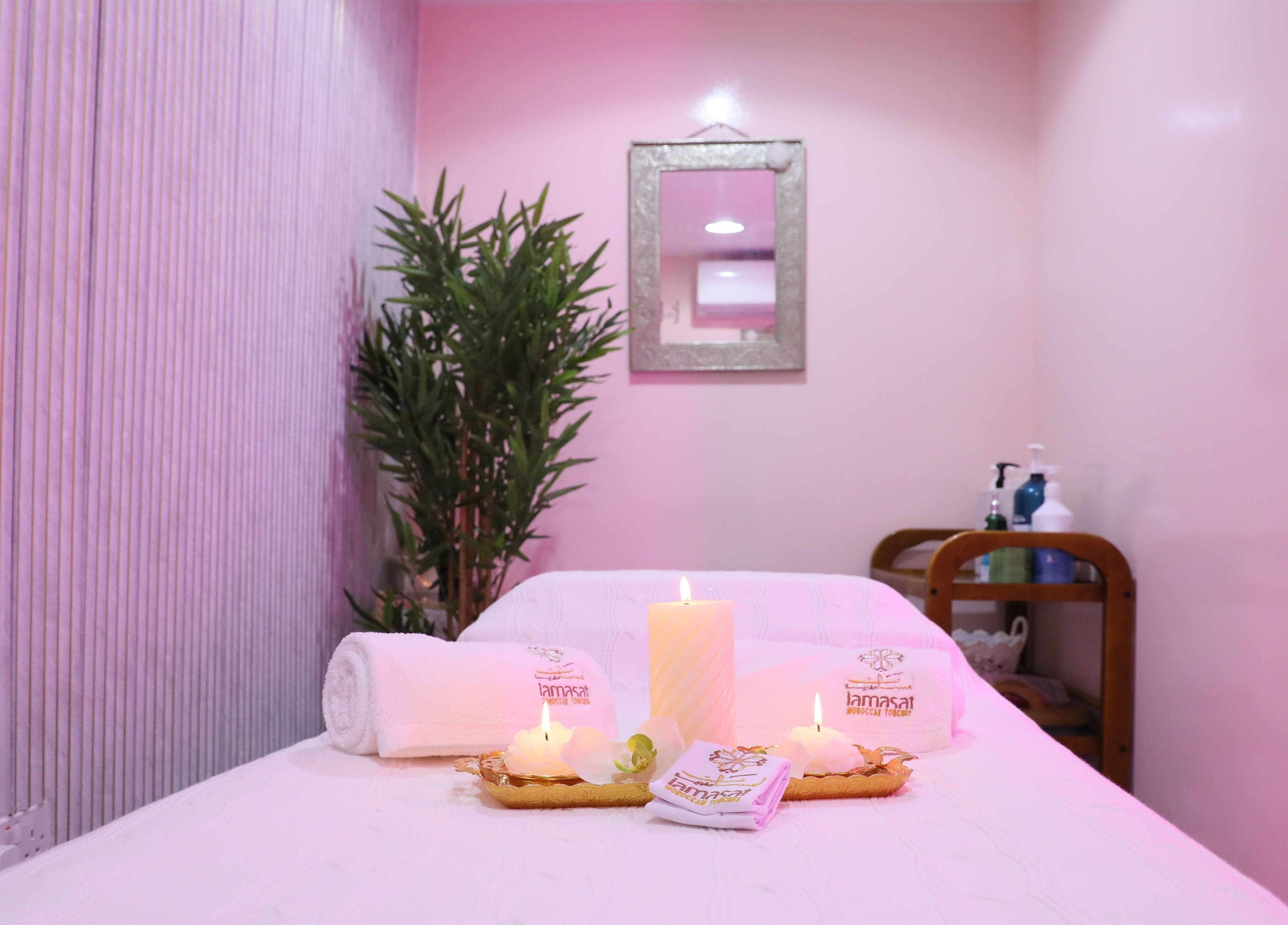 Tranquil massage room at Lamsat Magribyah Beauty Center, Doha, Al Rayyan Municipality, QA with candles and towels.