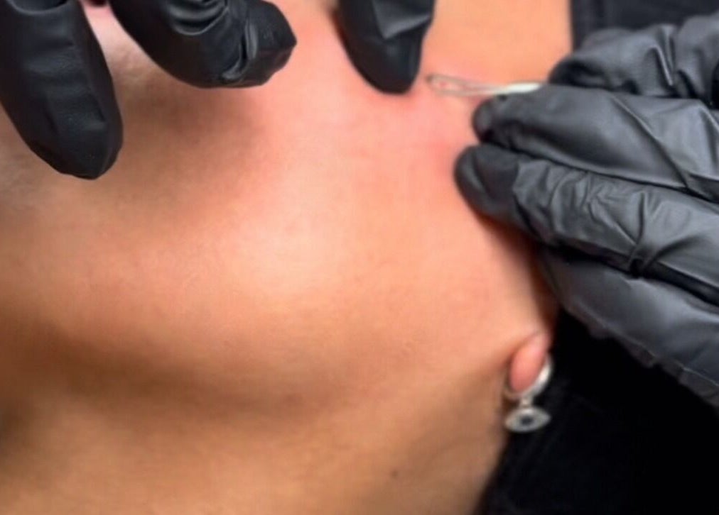 Facial treatment at SADE Aesthetics Berkshire, Reading, England, GB. Black-gloved hands performing skincare.