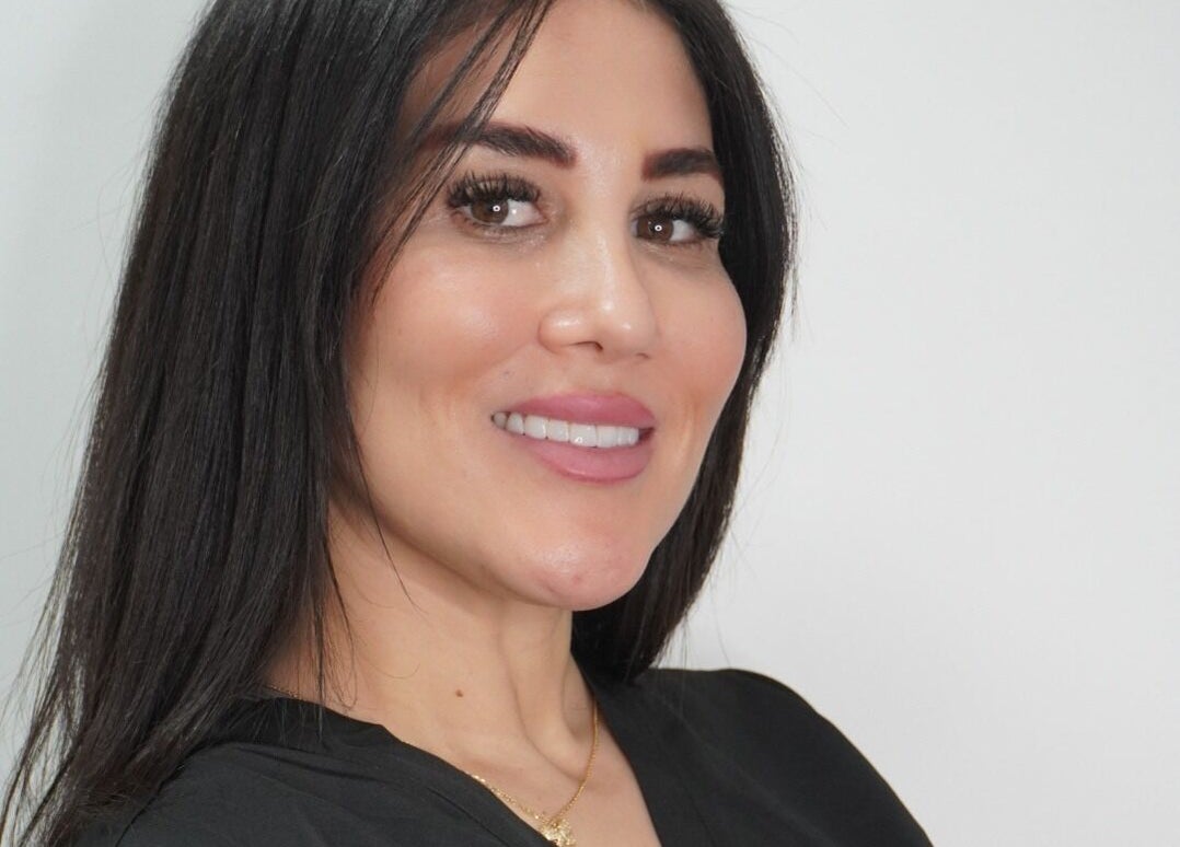 Smiling woman at SADE Aesthetics Berkshire in Reading, England, GB with dark hair and vibrant makeup.
