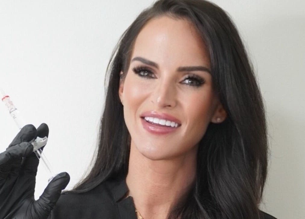 Professional injector at SADE Aesthetics Berkshire, Reading, England, GB, showcasing a syringe and confident smile.