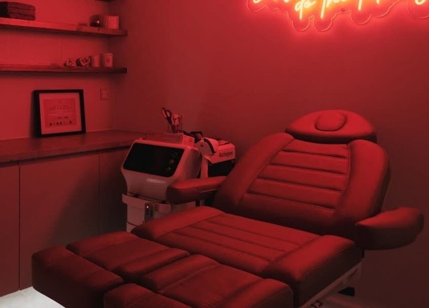 Tranquil treatment room at Sassy Aesthetics London LTD, London, England, GB, with red neon lights and modern decor.