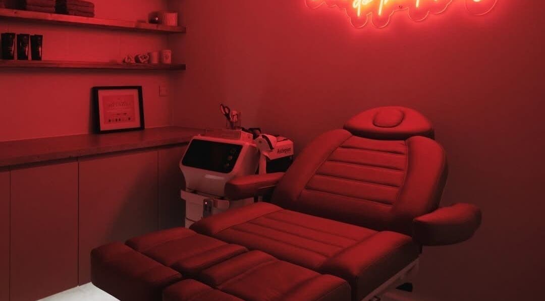 Tranquil treatment room at Sassy Aesthetics London LTD, London, England, GB, with red neon lights and modern decor.