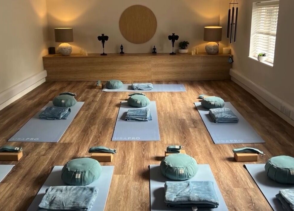 Meditation room at NOVA Wellness Clinic, Lyndhurst, England, GB, featuring yoga mats and cushions on wooden floor.