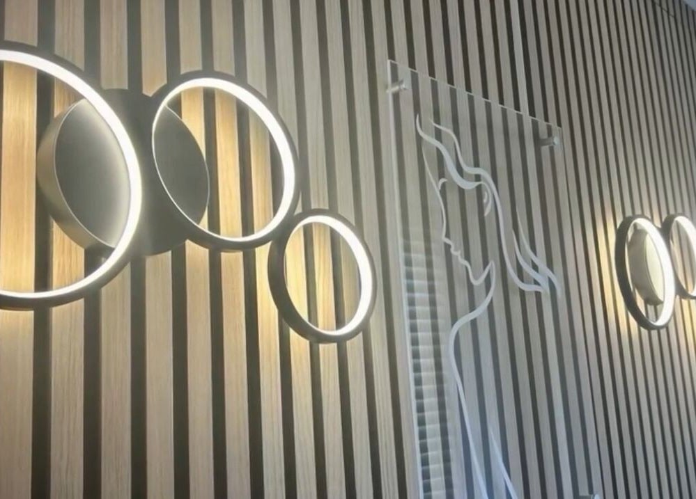 Contemporary circular lights on wooden wall at NOVA Wellness Clinic, Lyndhurst, England, GB.