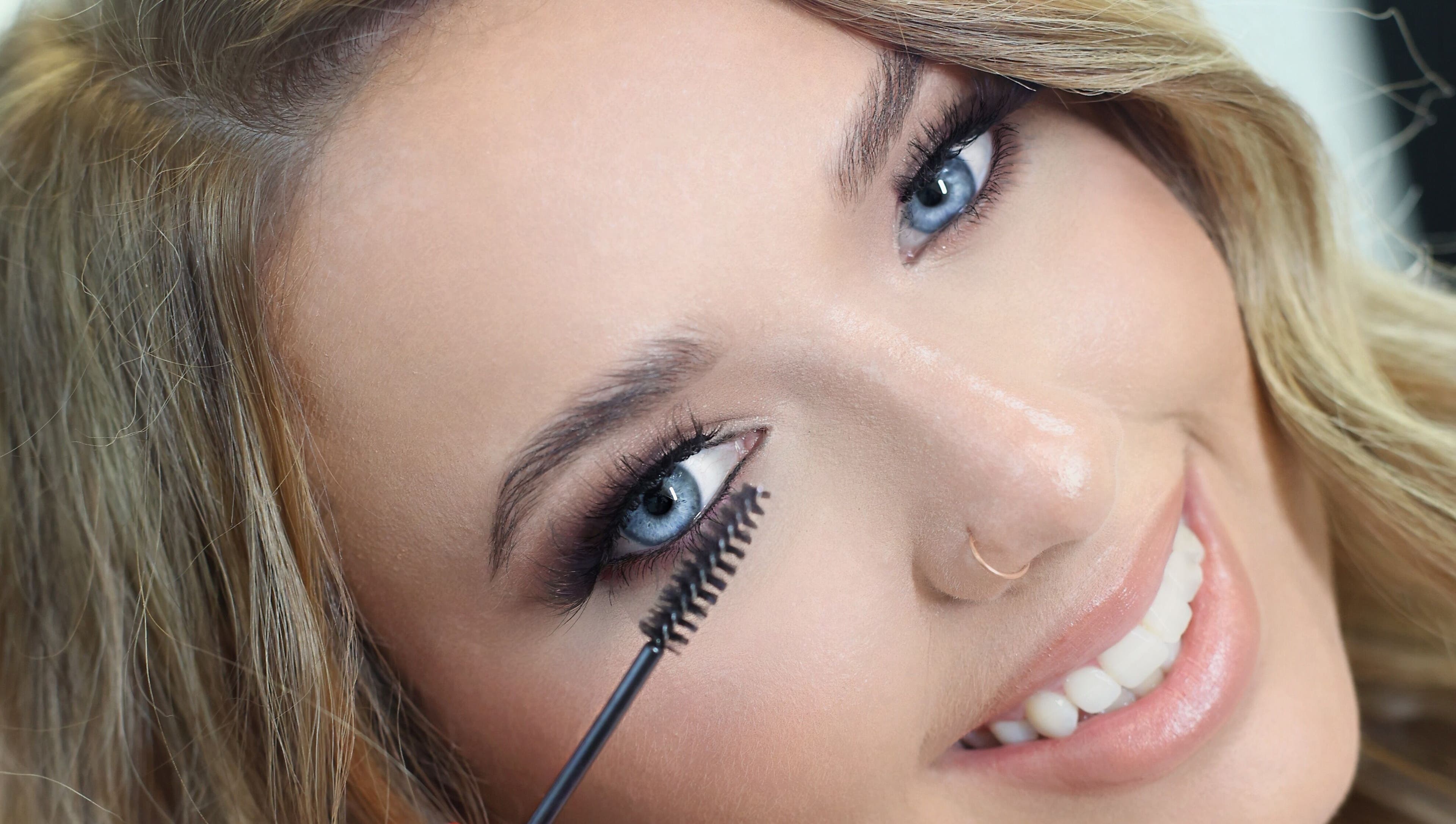Woman applying mascara at Brynn’s Beauty Bar, Spartanburg, South Carolina, US, showcasing lash styling technique.