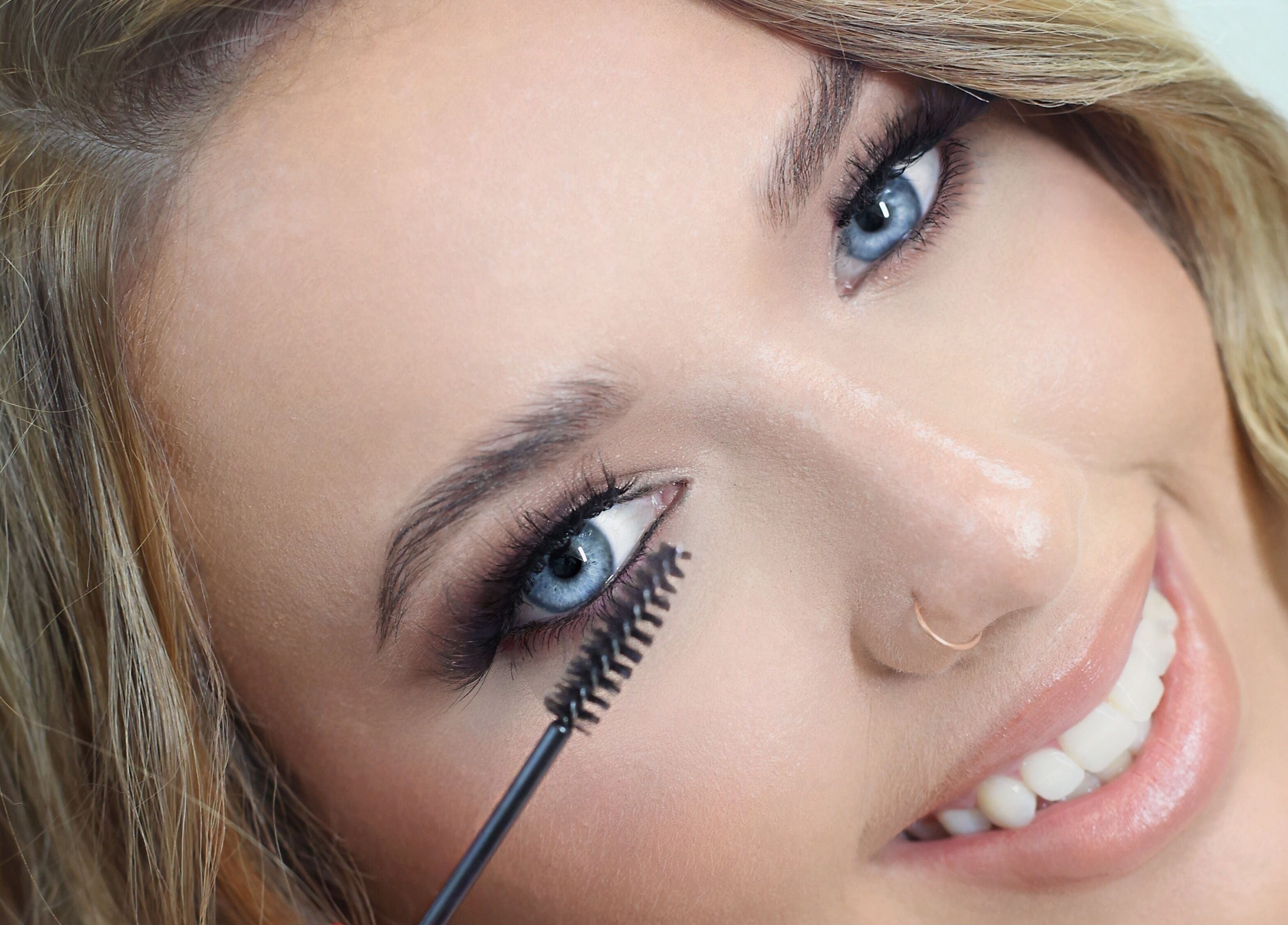 Woman applying mascara at Brynn’s Beauty Bar, Spartanburg, South Carolina, US, showcasing lash styling technique.