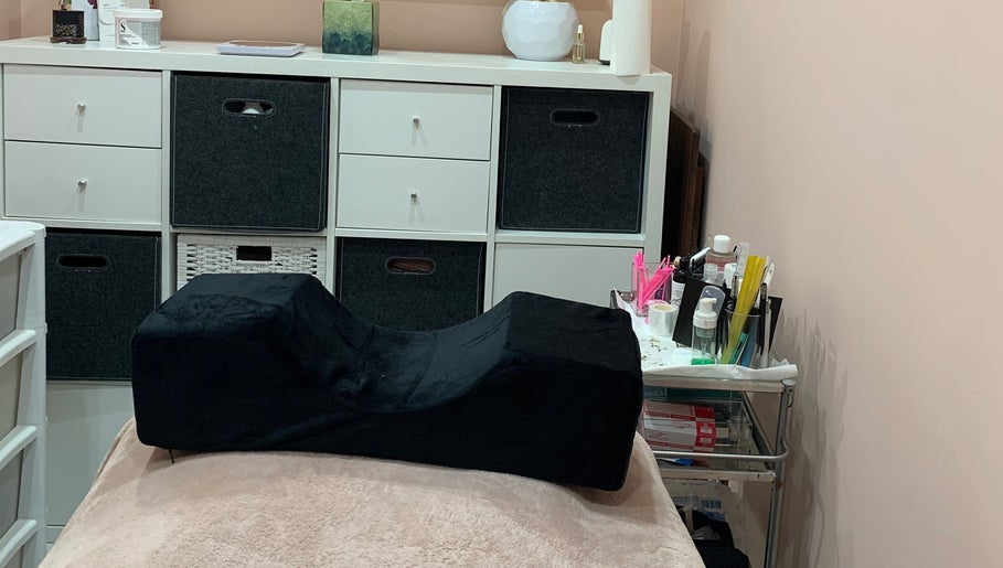 Cozy treatment room at Aura Beauty - Norbury, London, England, GB with a black cushion and organized supplies.